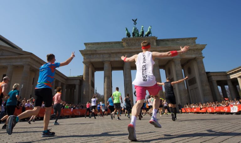 Runners cross the finish line of the Berlin Half Marathon 2025 at the Brandenburg Gate in Berlin.