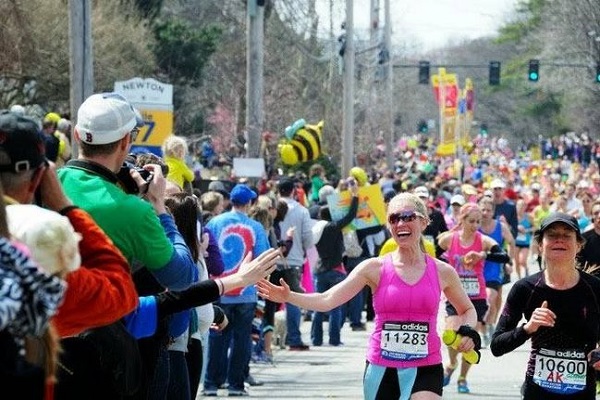 Runners interacting with crowds during the Boston Marathon 2025
