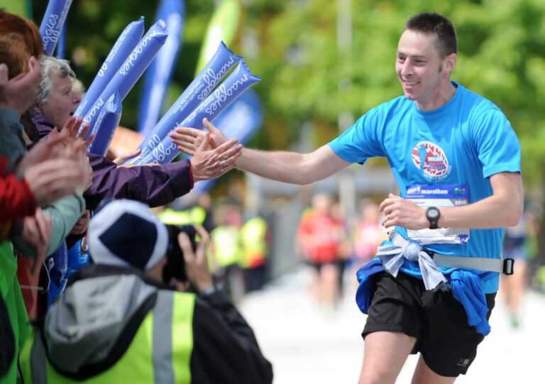 Photo of a runner interacting with crowds at the Edinburgh Marathon 2025