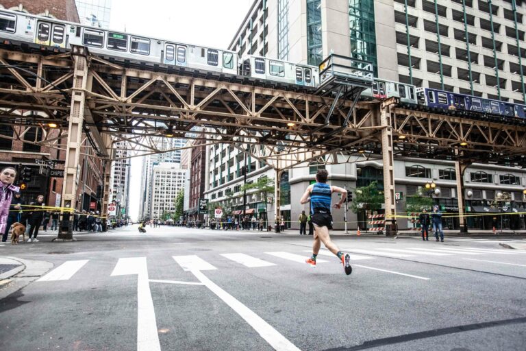 Picture of a Chicago Marathon 2024 runner passing beneath the Chicago metro system