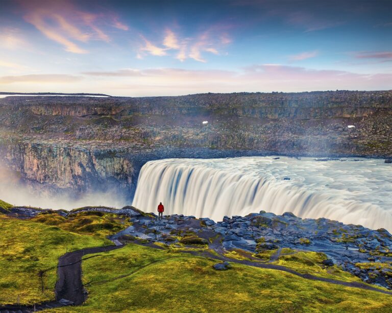 Runner passing a waterfall on the Iceland Volcano Marathon 2025