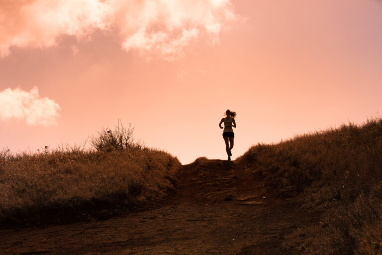 A female trail runner passes over the brow of a hill during the Trail Escape Manchester